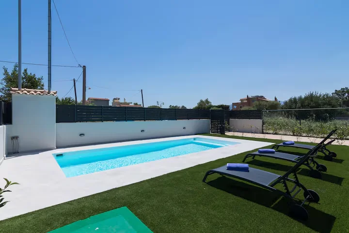 Spacious modern living room with comfortable seating and natural light in villa at Schinias, Athens